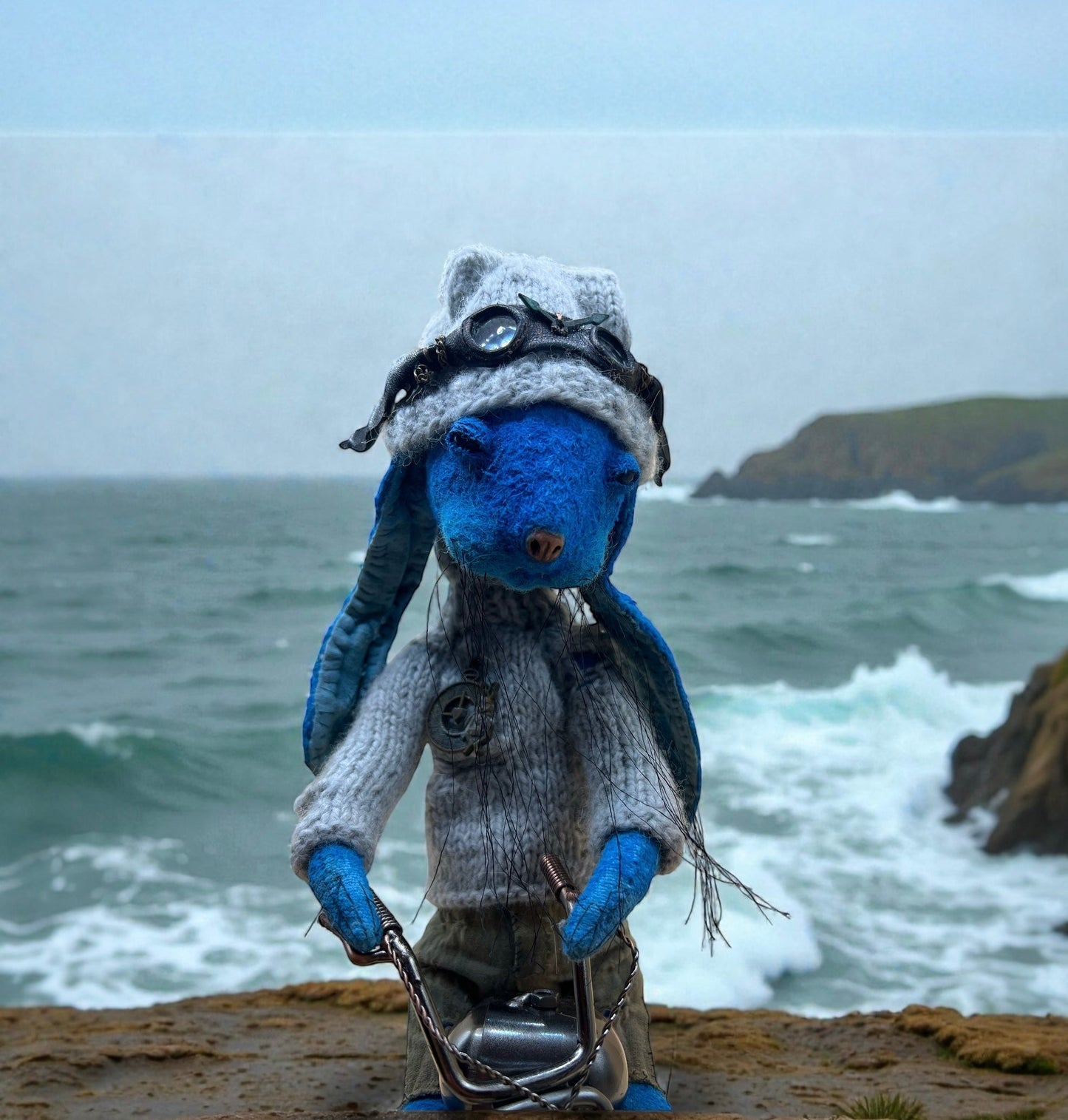 Blue bunny toy sitting on a motorcycle on an empty road surrounded by thick morning fog.